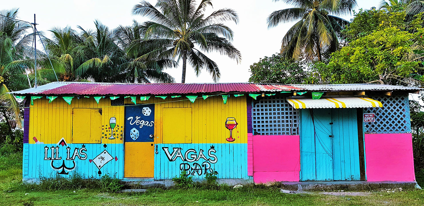 Colourful bar in Jamaica with palm trees behind
