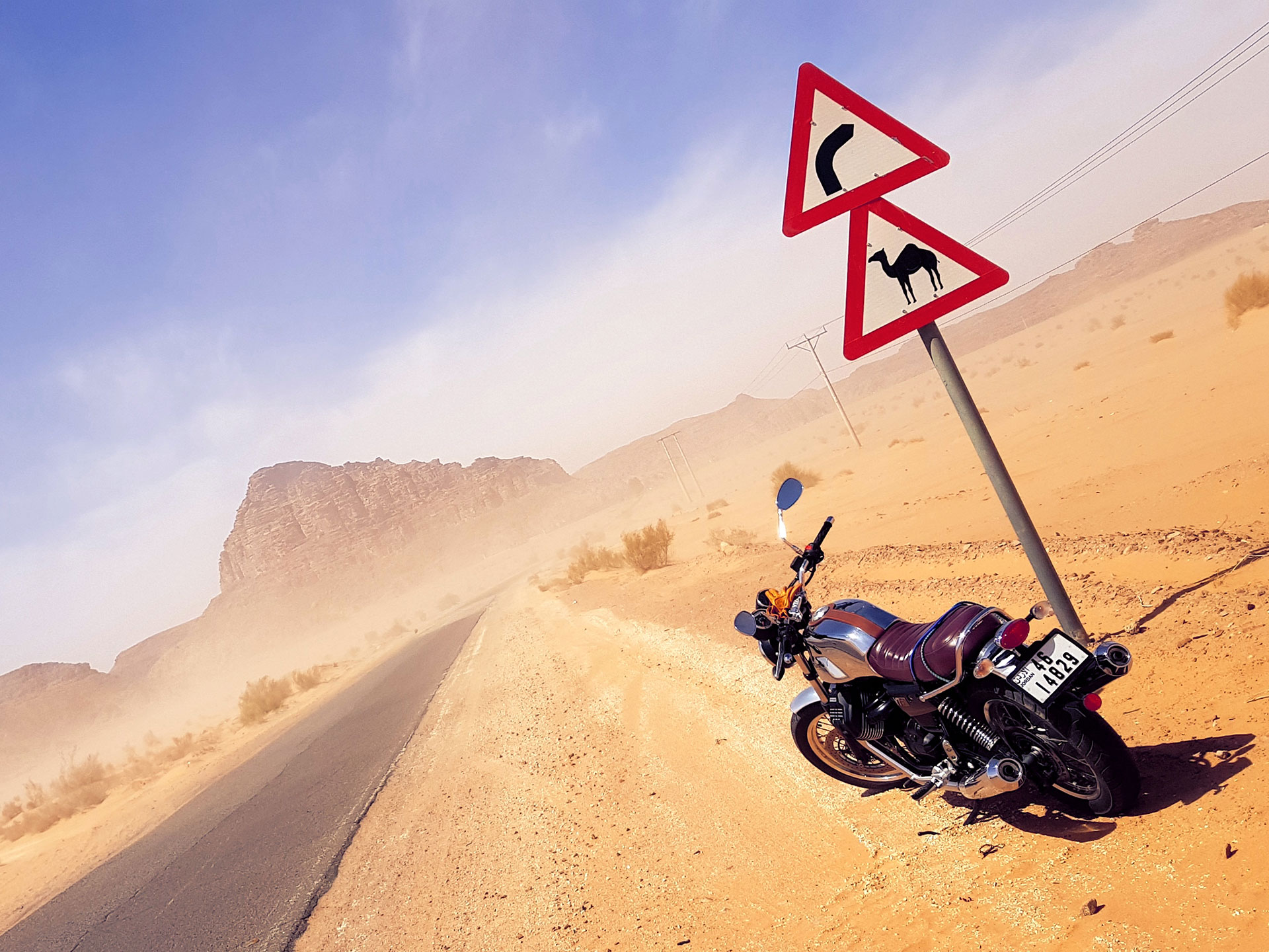 Motorbike by a camel road sign near a mountain in Jordan