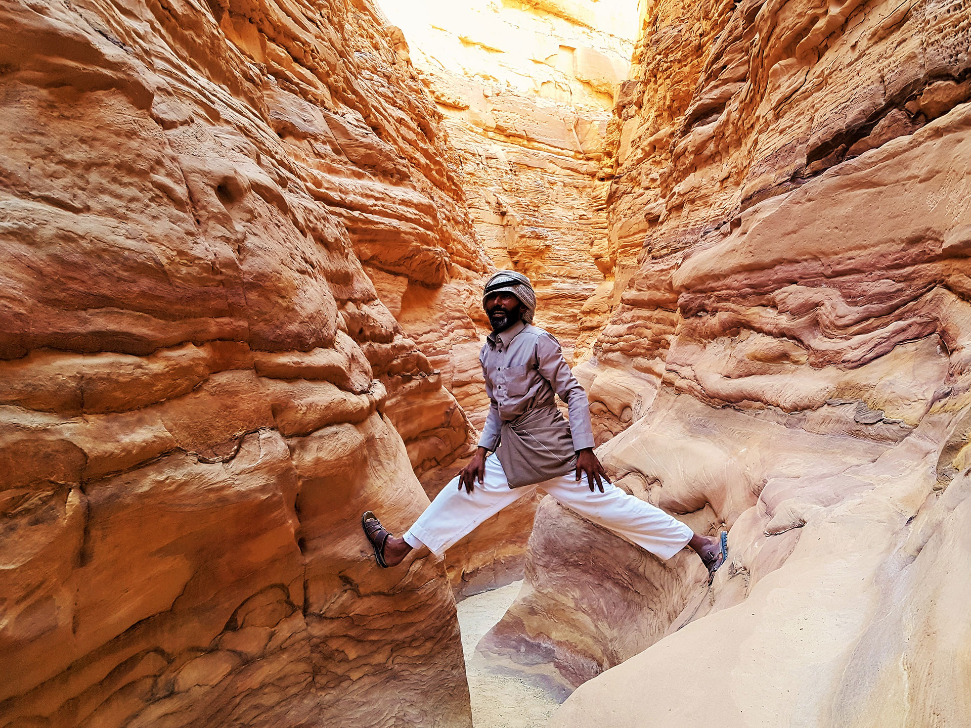 Musallem in the Sinai desert straddling two rocks in a canyon